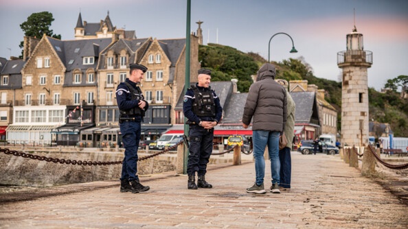 Deux gendarmes parlent avec deux personnes sur un pont dans une ville bretonne