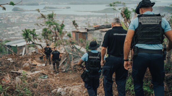 Les gendarmes et le DGGN se rendent sur une zone sinitr&eacute;e par l'ouragan. En fond, se trouve la mer et la ville qui s'&eacute;tend.
