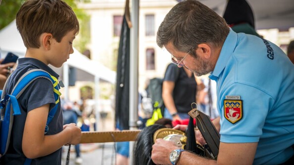 Un enfant obesrve un gendarme de la Garde républicaine avec son casque de cavalerie.