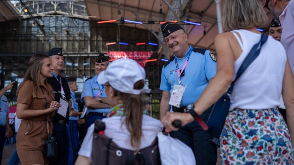 Le directeur général de la gendarmerie nationale, présent au Club France, sourit aux personnes présentes, que l'on aperçoit de dos.