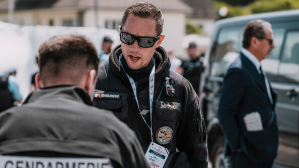 Deux gendarmes : en premier plan l'un est de dos et flou et l'autre est de face et net et porte un badge "Déminage". Ils sont en tenue sombre.