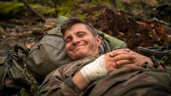 Un sous lieutenant se réveille de sa sieste, sourire aux lèvres, avec un bandage à la main