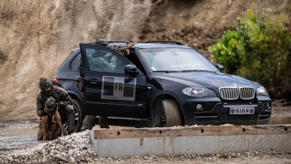 Deux membres du GIGN, dont un &eacute;quip&eacute; dun' arme longue, avec un chien surveillent les abords, prot&eacute;g&eacute;s par un 4x4 noir