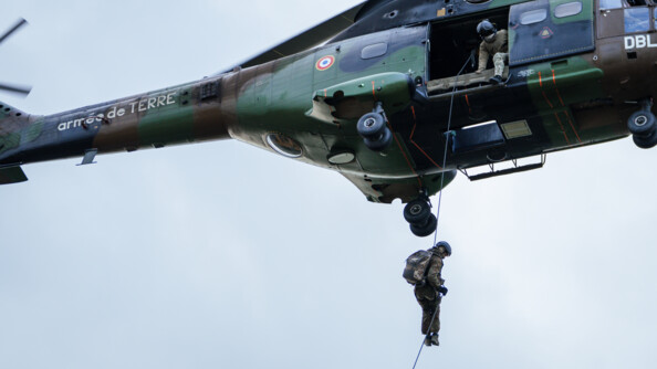 Un gendarme du GIGN descend en corde lisse depuis un Puma du GIH, sous le regard d'un autre militaire embarqu&eacute;.