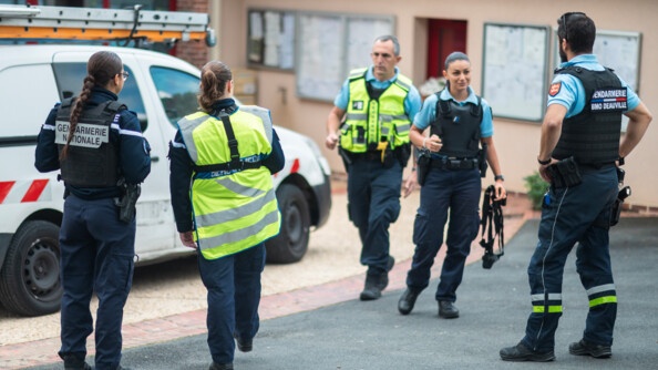 Cing gendarmes sur l'image, dont trois de dos et deux de face, se préparent pour une opération