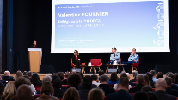 Photo de Valentine Fournier, qui intervient lors d'un colloque, s'exprimant au micro devant l'assembl&eacute;e, debout derri&egrave;re un pupitre en bois.