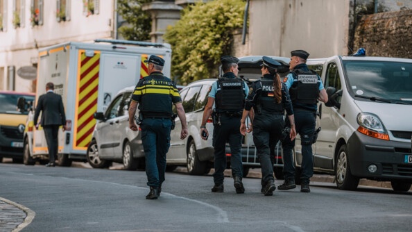 Deux gendarmes de dos avec un policiers belge et une policière allemande. Ils sont dans la rues.
