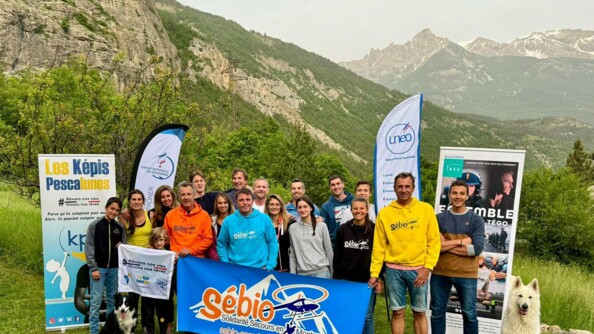 La quinzaine de pariticipants aux séjours "Rêves de Cimes" tenant les banderolles des associations devant les montagnes.