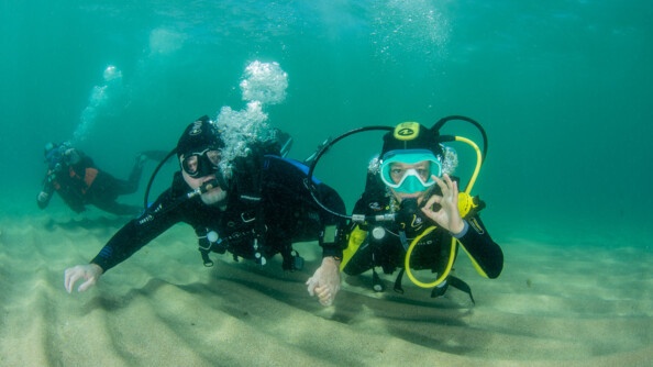 Photo prise dans l'eau lors du baptême de plongée de l'un des enfants. Sur la photo se trouve un enfant avec son accompagnateur.