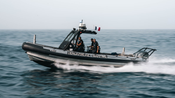 La photo représente un bateau de type zodiac avançant à vive allure sur la mer. Sur le flan du bateau est inscrit " Gendamerie maritime"