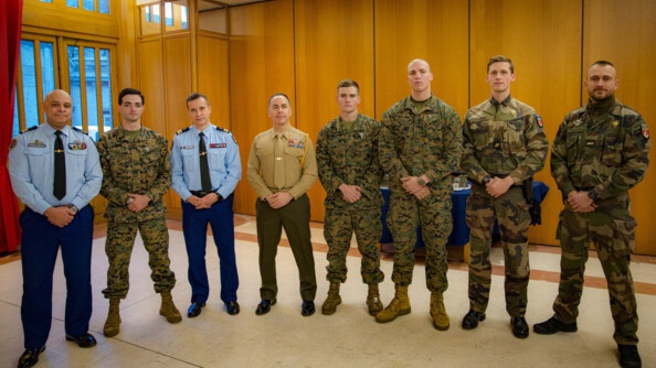 4 gendarmes et 4 Marines américain alignés, se tenant les mains devant le corps