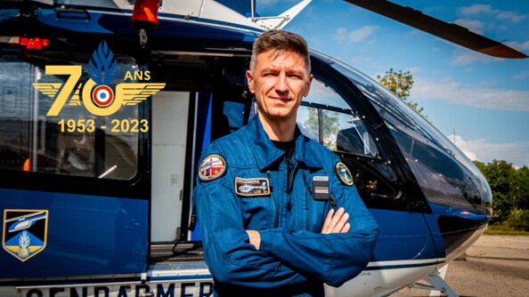 Pilote des Forces aérienne de la gendarmerie nationale devant un hélicoptère de la gendarmerie.