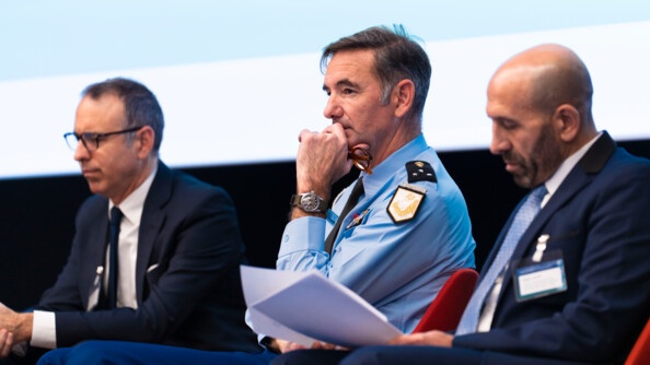 Photo de trois intervenants, dont un gendarme, situ&eacute; au centre, lors de la table ronde du colloque