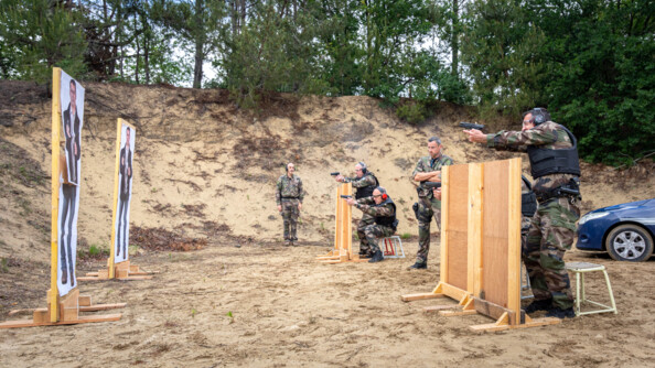 Plusieurs militaires de la GARM tirant derrière des protections.