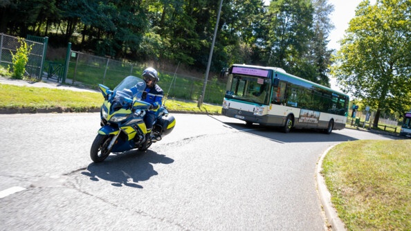 Motocycliste de la gendarmerie devant un bus de Paris 2024.