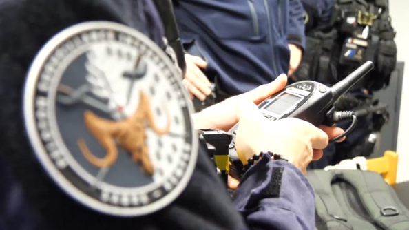Photo montrant un gendarme activant sa radio à l'occasion de l'opération "Tempête 29".