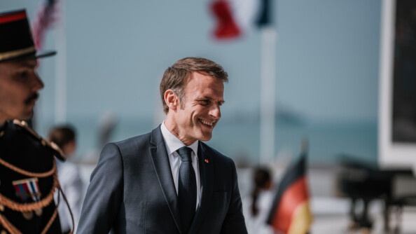 Image du président de la République en train de sourire avec à sa gauche, le profil d'un garde républicain en tenue d'apparat.
