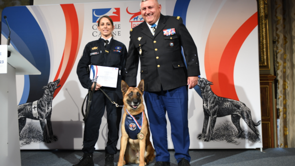 L'adjudante Mélanie, son malinois Looba et le général de corps d'armée Olivier Kim, directeur des opérations et de l'emploi sur la scène des trophées des chiens héros.