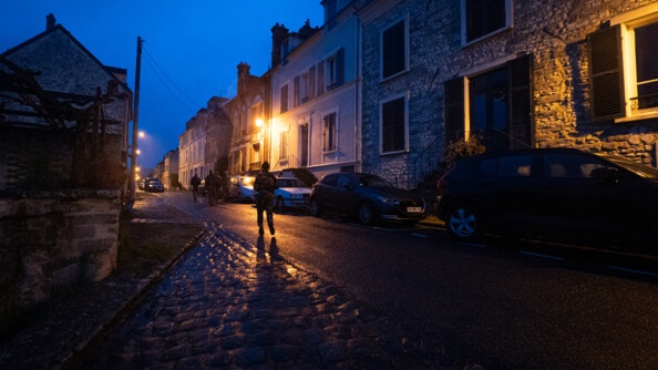 Un groupe de miliciens progressent de nuit dans un village