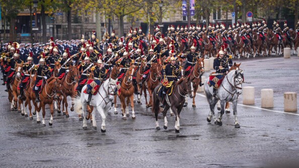 la cavalerie de la garde républicaine tourne autour d'un rond-point sur route pavée