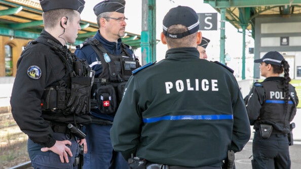 De dos un policier luembourgeois avec deux gendarmes fran&ccedil;ais sur le quai d'une gare.
