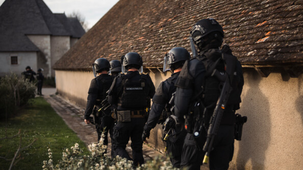 Des gendarmes d'un PSIG en colonne le long d'une habitation à proximité de Chambord