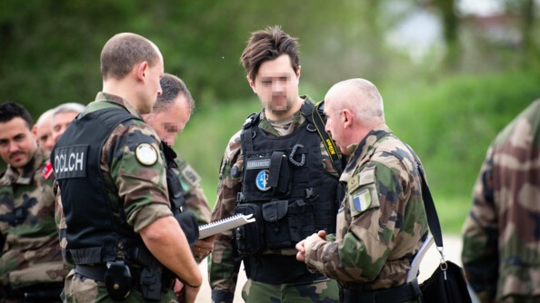 Des gendarmes en treillis échangent entre eux sur l'avancée de l'enquête.