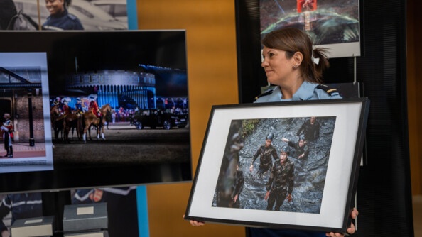 La gendarme tient dans ses mains la photo de Florian Garcia qui a &eacute;t&eacute; choisi par J&eacute;r&ocirc;me Pitorin. La photo repr&eacute;sente une femme en treilli qui d&eacute;couvre un obstacle dans un parcour du combattant. Sa bouche est grande ouverte et elle est surprise. Autour d'elle, ses camarades en treilli sont aussi dans l'eau.