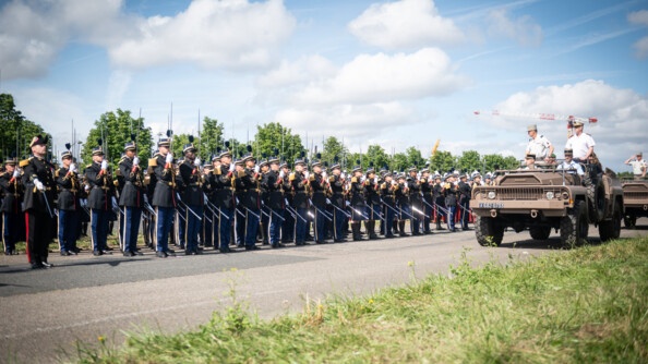Les élèves-officiers de la gendarmerie présentent les armes aux autorités les passant en revue à partir d'un véhicule militaire
