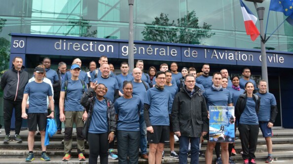 Un groupe d'une trentaine de coureurs sur les marches devant la DGAC au départ de la course