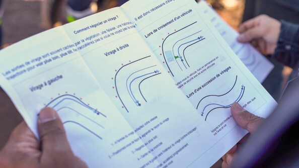 Vue en gros plan d'un papier sur lequel se trouve des conseils pour réaliser de bonnes trajectoires en deux roues.