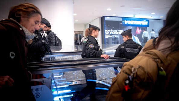 Trois gendarmes mobiles s'apprêtent à descendre un escalator