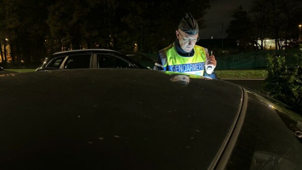 Un gendarme contr&ocirc;le un v&eacute;hicule de nuit.