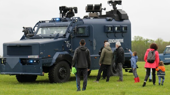 Sept enfants et adultes au pied d'un Centaure de la gendarmerie