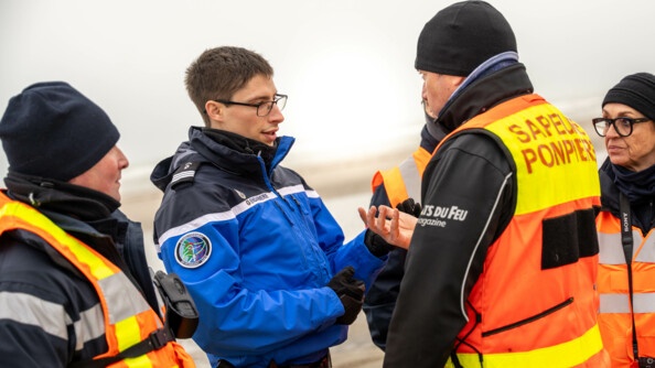 Photo du capitaine Arthur Ribeiro DE CARVALHO, membre du CESAN, sur la plage discutant avec les sapeurs pompiers.