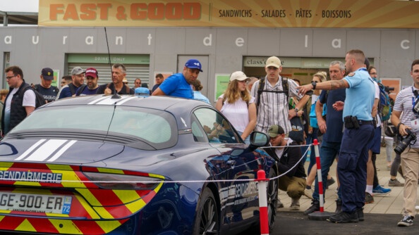 Stand de la GN. L'alpine gendarmarie est au centre de l'image et les visiteurs prennent des photos de la voiture