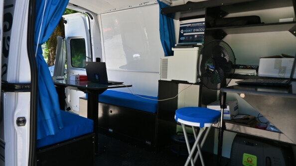 L'intérieur du Gendtruck avec des siéges bleus et des ordinateurs, soit tout le nécessaire pour réaliser différentes procédures.