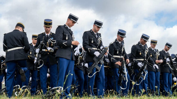 Les élèves-gendarmes en vareuse préparent leur gants et FAMAS pour les répétitions