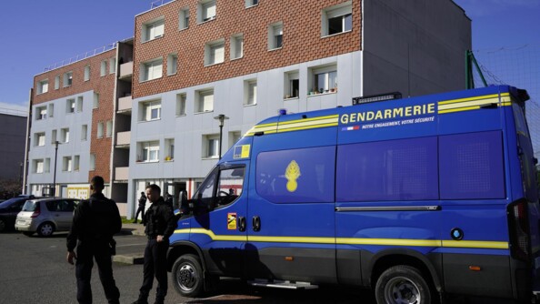 Deux gendarmes mobiles devant un véhicule de maintien de l'ordre au pied d'un immeuble
