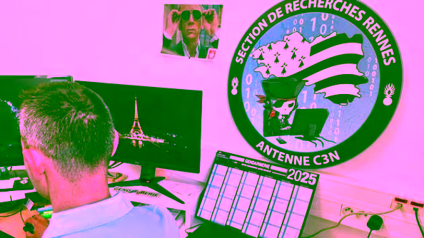 Photo d'un gendarme de dos, assis devant un ordinateur. Un gros écusson accroché au mur comprte l'inscription "Antenne C3N"