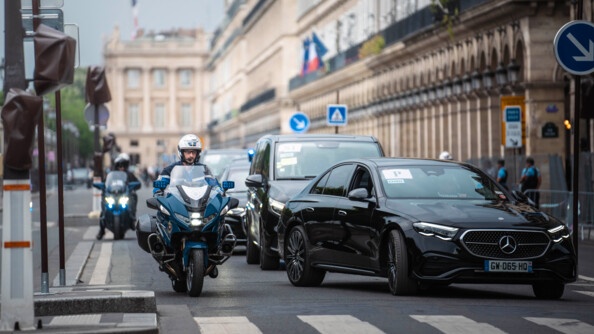 Deux motocyclistes slalomant dans Paris pour accompagner la délégation chinoise.