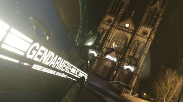 Un véhicule de gendarmerie sérigraphié au pied d'une église