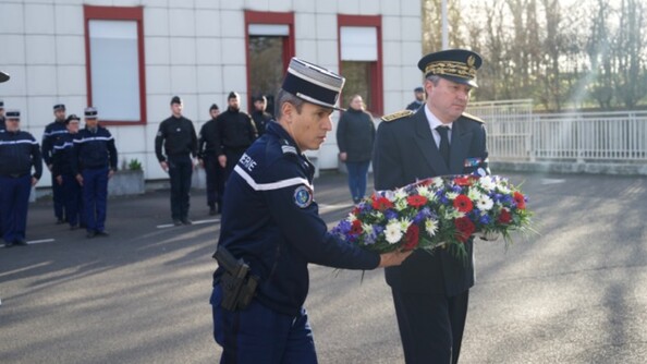 Une autorité civile et une autorité militaire déposent une gerbe de fleurs.