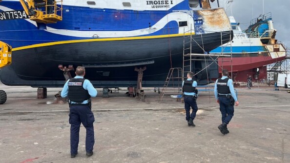 Trois gendarmes &eacute;voluent autour d'un bateau bleu et blanc, enti&egrave;rement sorti de l'eau, portant sur la coque l'inscription "Iroise 1"