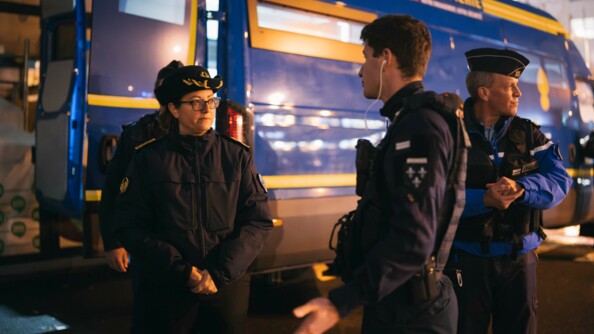 UN lieutenant de PSIG échange avec une préfète devant ses chefs et un véhicule de maintien de l'ordre