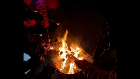 Dans la nuit, des enfants font chauffer des chamalows