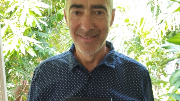 Le visage de Manuel Azuaga avec le haut de son roman laissant apparaitre le titre "la rédemption du tueur". Derrière le fond est composé de végétation.
