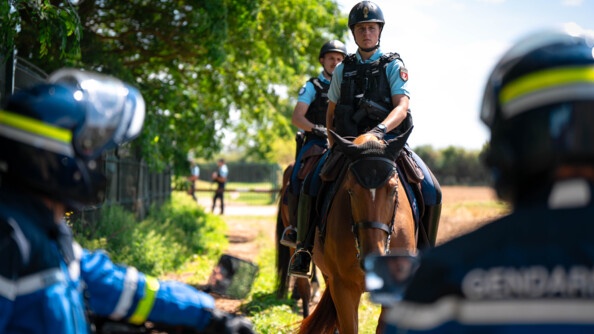 Patrouille de cavaliers de la Garde Républicaine et motocyclistes tout terrain (de dos)