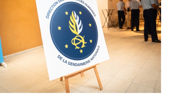 Le nouveau logo de la DRHGN sur un chevalet. A droite quelques gendarmes