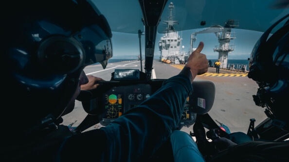 Pilote d'hélicoptère des Forces aériennes de la gendarmerie nationale qui fait un signe - pouce levé - au "chien jaune" sur le pont du Porte hélicoptères Amphibie Mistral.